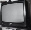 Black and white image of an old television with antenna on a stand.